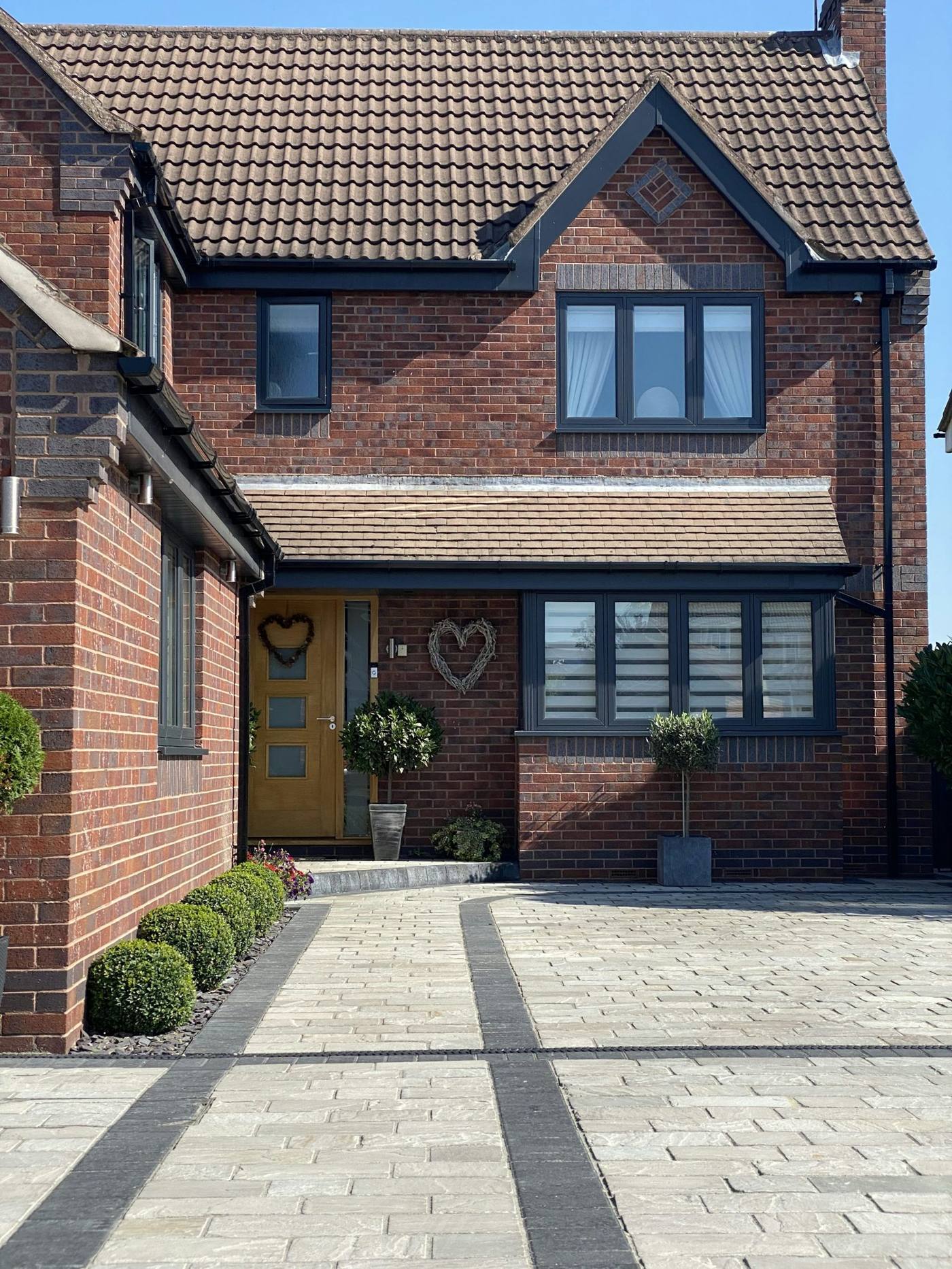 Red-brick house with clean paved driveway