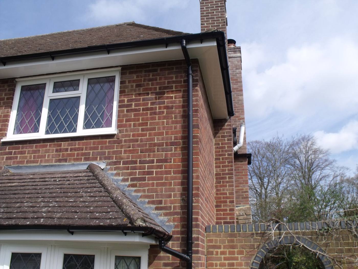 Clean black guttering on a British brick house